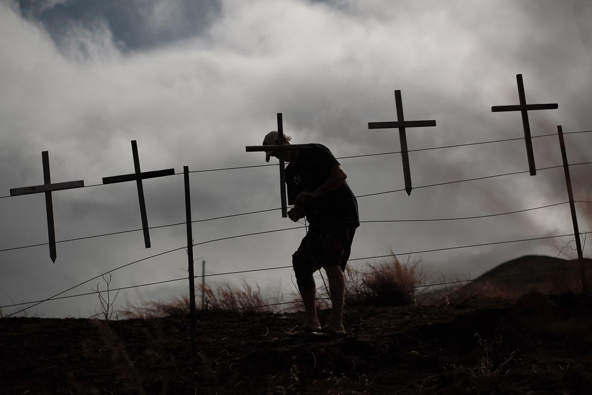 Lots of crosses are attached by local residents to mourn the victims on a hill overlooking Lahaina, the western part of the Maui island, which has been devastated by wildfire, in Maui, Hawaii, United States on August 21, 2023.( The Yomiuri Shimbun ) (Photo by Hiroto Sekiguchi / Yomiuri / The Yomiuri Shimbun via AFP)