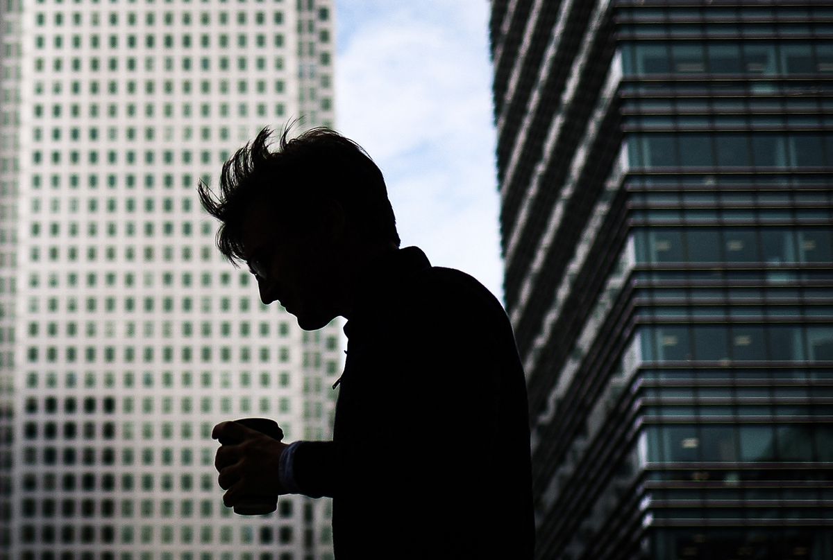 A pedestrian carries a coffee cup in London's central business district of Canary Wharf, on August 14, 2023. The British Office for National Statistics (ONS) will release new data on the job market on August 15 morning. The unemployment rate in the three months to the end of June 2023 is expected to remain unchanged at 4.0%, according to a consensus supplied by Pantheon Macroeconomics. But experts are expecting a considerable slowdown in employment growth. (Photo by HENRY NICHOLLS / AFP)