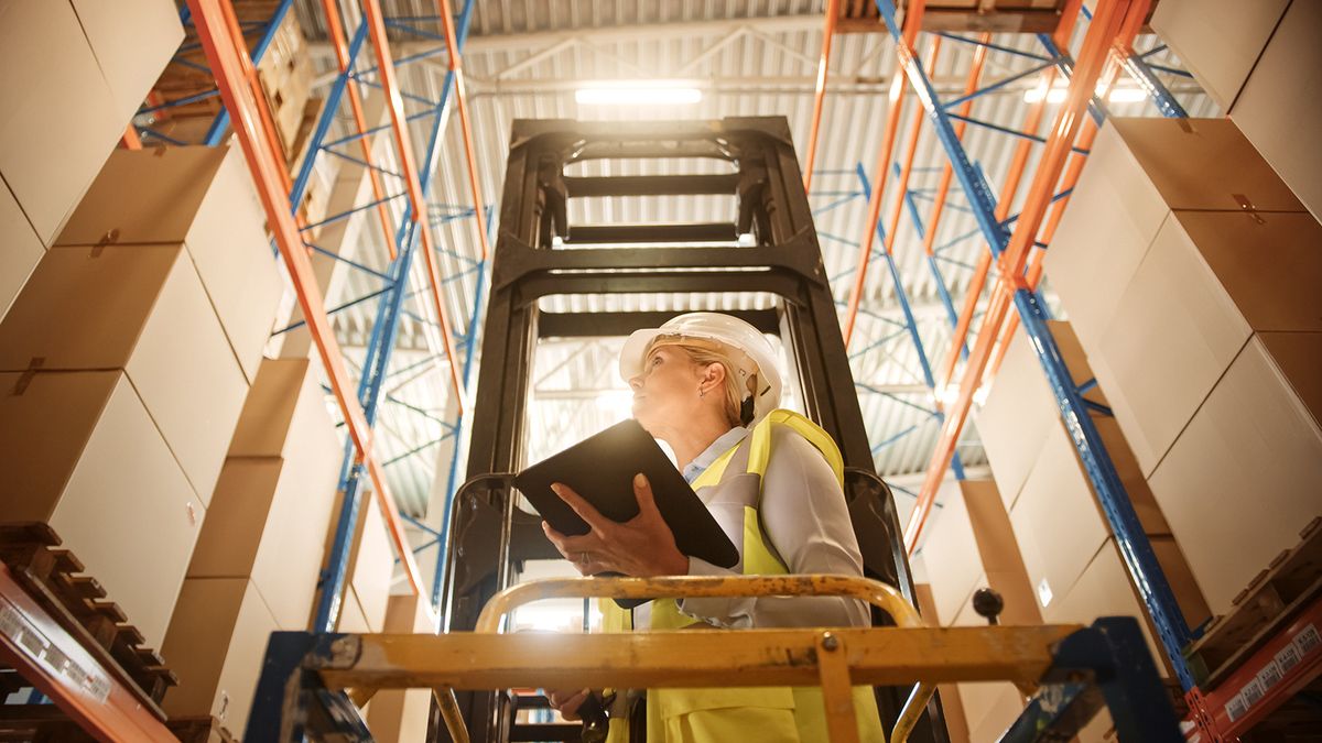 Professional,Female,Worker,Wearing,Hard,Hat,Lifts,Herself,On,Aerial
Professional Female Worker Wearing Hard Hat Lifts Herself on Aerial Work Platform to Check Stock and Inventory with Digital Tablet on the Higher Level of Retail Warehouse full of Shelves with Goods
