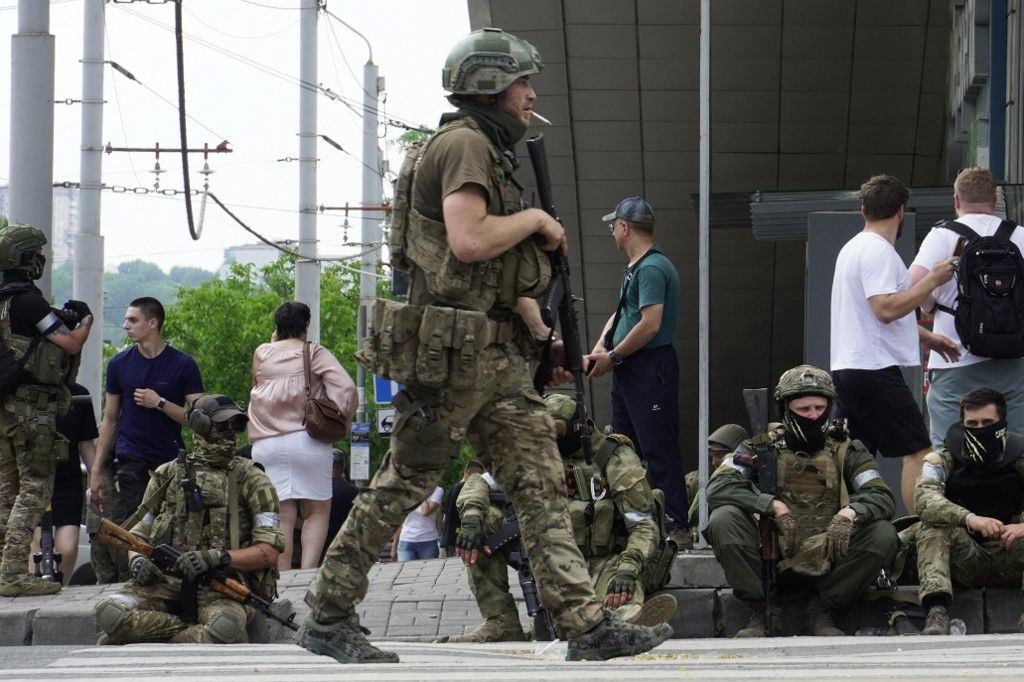 Members of Wagner group sit on the sidewalk as they patrol the center of Rostov-on-Don, on June 24, 2023. President Vladimir Putin on June 24, 2023 said an armed mutiny by Wagner mercenaries was a "stab in the back" and that the group's chief Yevgeny Prigozhin had betrayed Russia, as he vowed to punish the dissidents. Prigozhin said his fighters control key military sites in the southern city of Rostov-on-Don. (Photo by STRINGER / AFP)