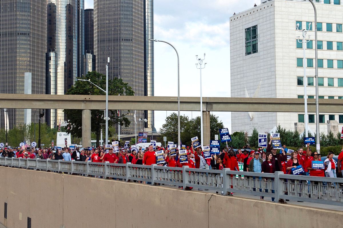 Members of the United Auto Workers (UAW) union march through the streets of downtown Detroit following a rally on the first day of the UAW strike in Detroit, Michigan, on September 15, 2023. Workers at the "Big Three" US auto manufacturers went on strike on September 15, 2023, in a first-ever coordinated action to demand pay raises, testing the resilience of the US economy and threatening President Joe Biden's 2024 re-election momentum. (Photo by Matthew Hatcher / AFP)