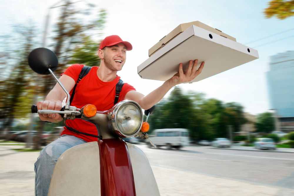 Joyful,Man,Is,Delivering,Pizza.,Deliveryman,Uses,A,Company,Motorbike
