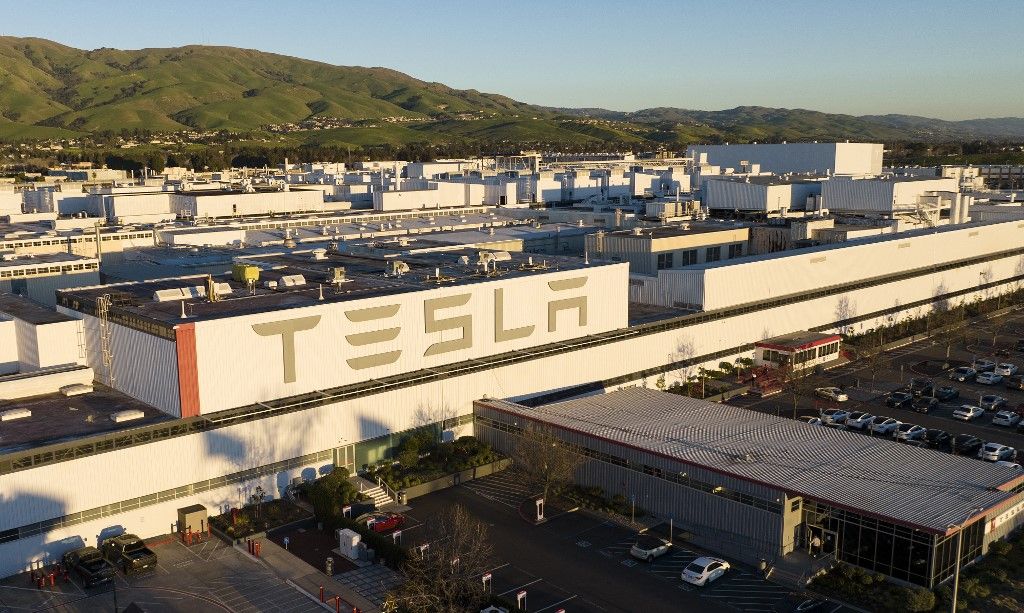 An aerial view shows the Tesla Fremont Factory in Fremont, California on February 10, 2022. Tesla can hardly make enough electric vehicles to meet booming demand, but behind the world's most valuable auto brand is its troubled California factory that makes most of those cars. The Fremont plant near San Francisco has seen a spate of sexual harassment lawsuits, years of racism allegations -- including a California civil rights agency complaint this week -- and even a murder last year (Photo by JOSH EDELSON / AFP)