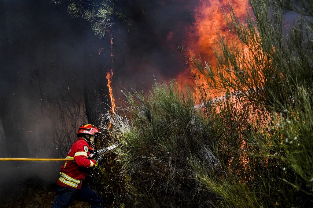 A firefighter extinguishes a wildfire in the Sameiro village near the town of Manteigas, on August 10, 2022. A wildfire that broke out on Saturday has been raging in the natural park of Serra da Estrela in central Portugal. (Photo by PATRICIA DE MELO MOREIRA / AFP) / ALTERNATIVE CROP