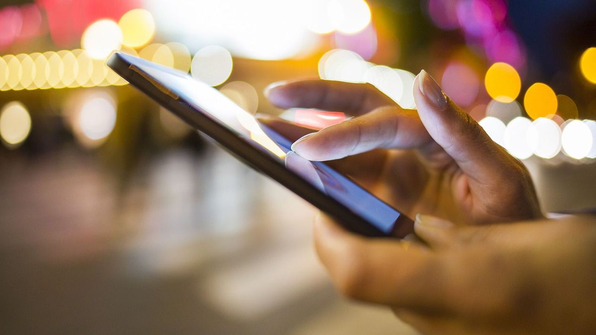 Woman,Using,Her,Mobile,Phone,In,The,Street,,Night,Light