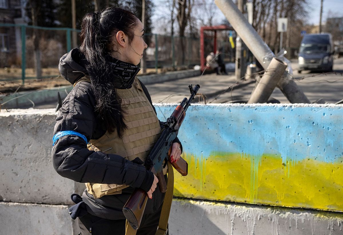 A volunteer takes position at a checkpoint in a district in Kyiv, on March 20, 2022. A shell exploded outside an apartment block in Kyiv, wounding five people, the mayor said Sunday, the latest bombardment as Russian forces try to encircle the Ukranian capital. (Photo by FADEL SENNA / AFP)