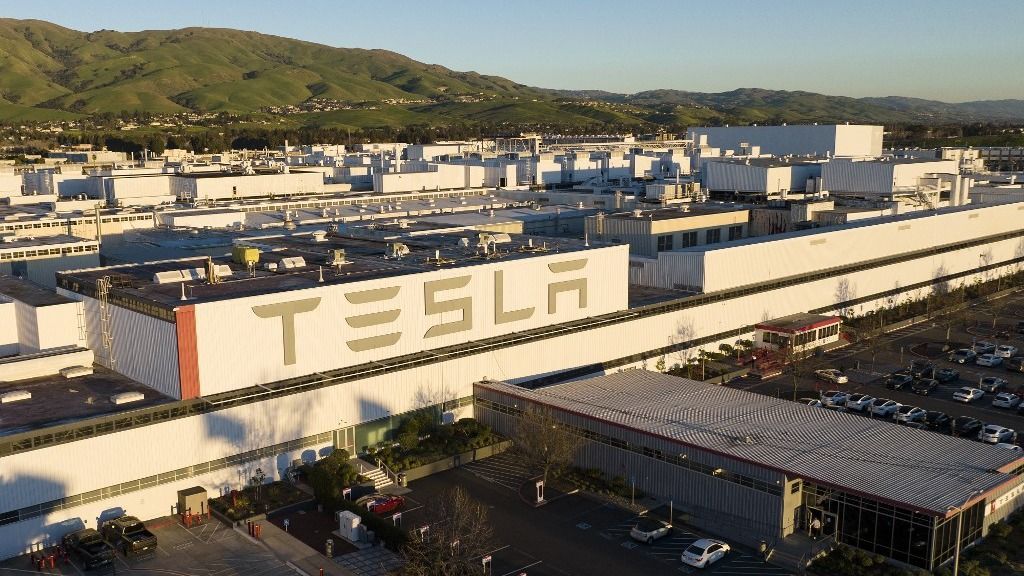 An aerial view shows the Tesla Fremont Factory in Fremont, California on February 10, 2022. Tesla can hardly make enough electric vehicles to meet booming demand, but behind the world's most valuable auto brand is its troubled California factory that makes most of those cars. The Fremont plant near San Francisco has seen a spate of sexual harassment lawsuits, years of racism allegations -- including a California civil rights agency complaint this week -- and even a murder last year (Photo by JOSH EDELSON / AFP)