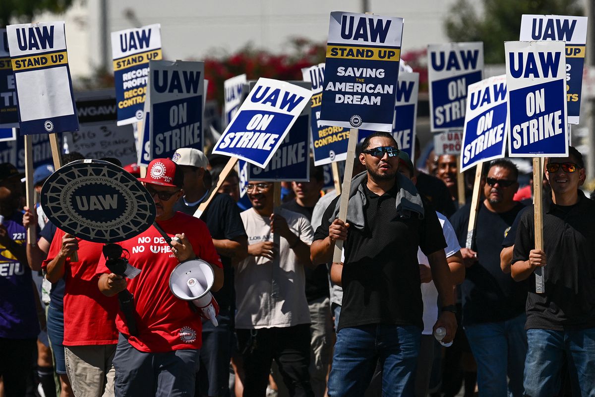 Members of the United Auto Workers (UAW) Local 230 and their supporters walk the picket line in front of the Chrysler Corporate Parts Division in Ontario, California, on September 26, 2023, to show solidarity for the "Big Three" autoworkers currently on strike. Some 5,600 UAW members walked out of 38 US parts and distribution centers at General Motors and Stellantis at noon September 22, 2023, adding to last week's dramatic worker walkout. The UAW has described its campaign as an effort to level the economic playing field for the working class. (Photo by Patrick T. Fallon / AFP)