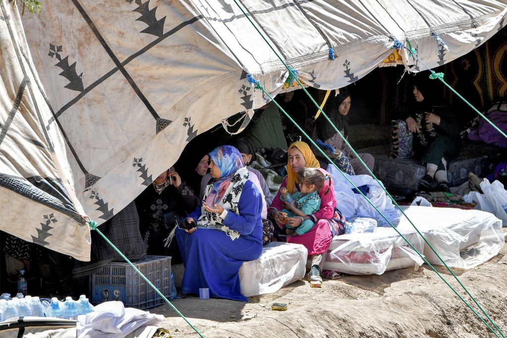 Survivors of the deadly 6.8-magnitude September 8 earthquake gather under a tent in the village of Tikht near Adassil in central Morocco on September 10, 2023. Using heavy equipment and even their bare hands, rescuers in Morocco on September 10 stepped up efforts to find survivors of a devastating earthquake that killed more than 2,100 people and flattened villages. (Photo by FETHI BELAID / AFP)
