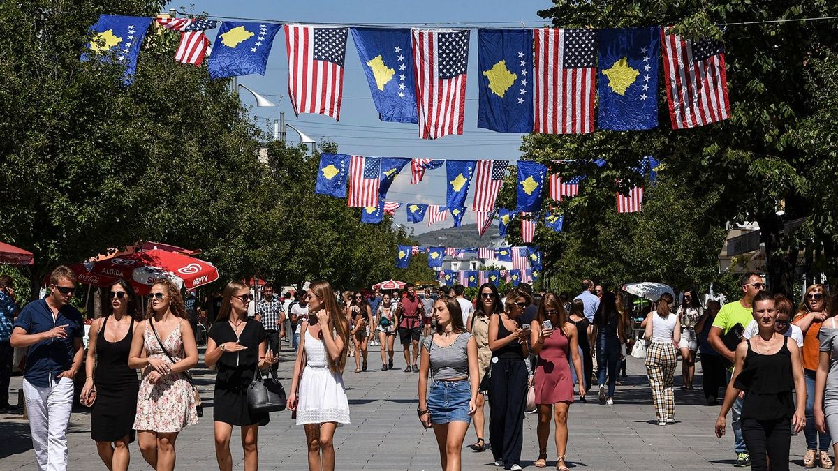 Kosovo Albanians walk through the Mother Teresa square decorated with Kosovo and US flags ahead of the visit of the United States Vice President Joe Biden, in Pristina on August 16, 2016. US Vice President Joe Biden starts a visit to the Balkans in Belgrade, where he will meet Serbian President Tomislav Nikolic and Prime Minister Aleksandar Vucic. (Photo by ARMEND NIMANI / AFP)