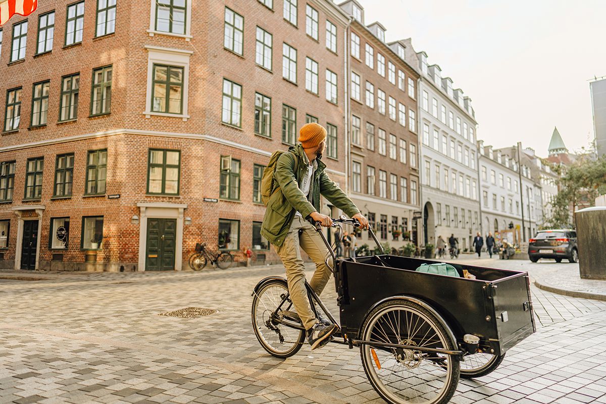 Young man riding a cargo bike in the city