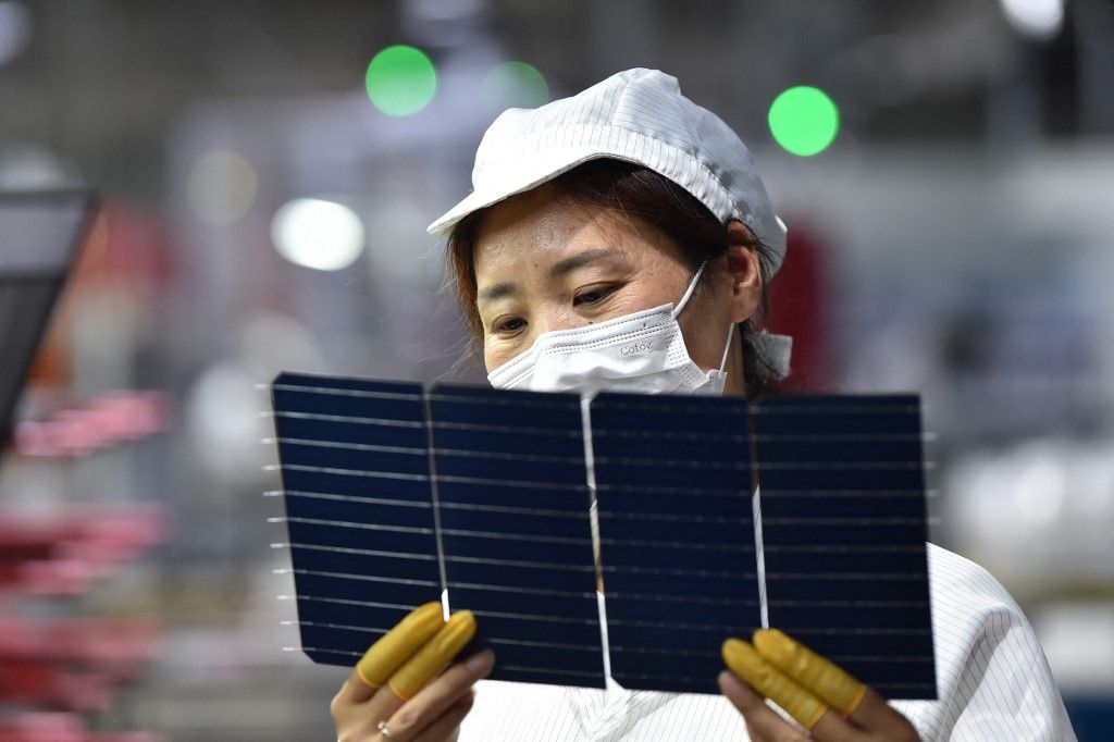 A worker checks solar photovoltaic modules used for solar panels at a factory in Suqian in China's eastern Jiangsu province on May 9, 2023. (Photo by AFP) / China OUT