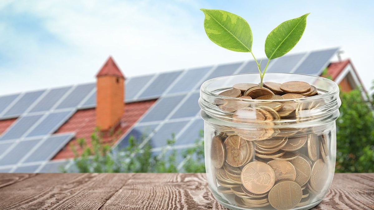 Glass,Jar,With,Coins,And,Plant,Against,House,With,Installed,Glass jar with coins and plant against house with installed solar panels on roof. Economic benefits of renewable energy