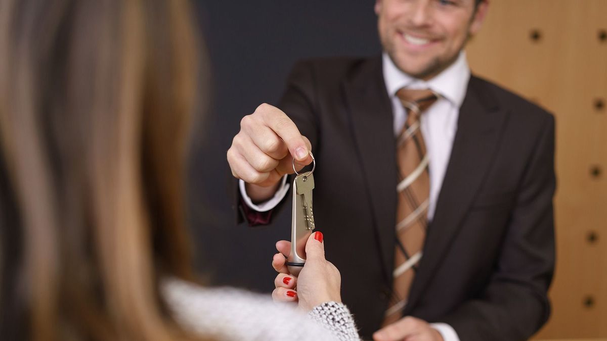 Smiling,Hotel,Manager,Handing,Over,A,Door,Key,To,A