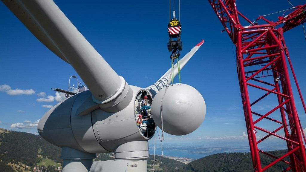 Workers is seen pulling the rotor cap of a new wind turbine of Romande Energie, a Switzerland-based company of production and distribution of electricity after it has been erected on August 8, 2023 above Sainte-Croix. A study by the federal technology institute ETH Zurich has concluded that, in order to meet the government’s 2050 energy target, Switzerland would need 760 wind turbines, nearly 20 times the current number. (Photo by Fabrice COFFRINI / AFP)