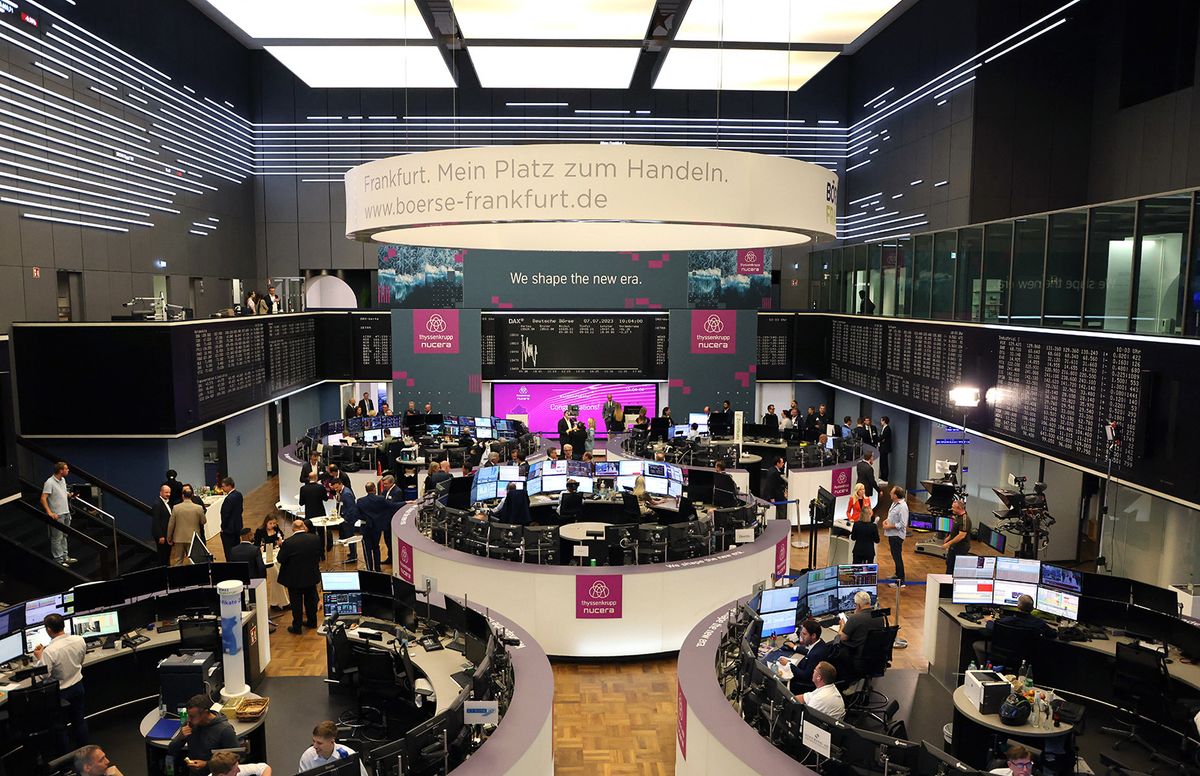 A display (back C) shows the German Stock Market Index DAX at the Stock Exchange in Frankfurt am Main, western Germany, on July 7, 2023 during the launch of Thyssenkrupp's initial public offering IPO of Nucera. German industrial giant Thyssenkrupp launched the IPO of its hydrogen unit Nucera on July 7, one of the biggest European market floatations this year as interest grows in the shift to green technologies. As countries around the world look at ways to reduce carbon emissions to help meet climate targets, hydrogen has increasingly come into focus as an alternative to fossil fuels. Nucera produces electrolysers, which can be used to manufacture green hydrogen made using electricity obtained through renewable energy sources such as solar or wind. (Photo by Daniel ROLAND / AFP)