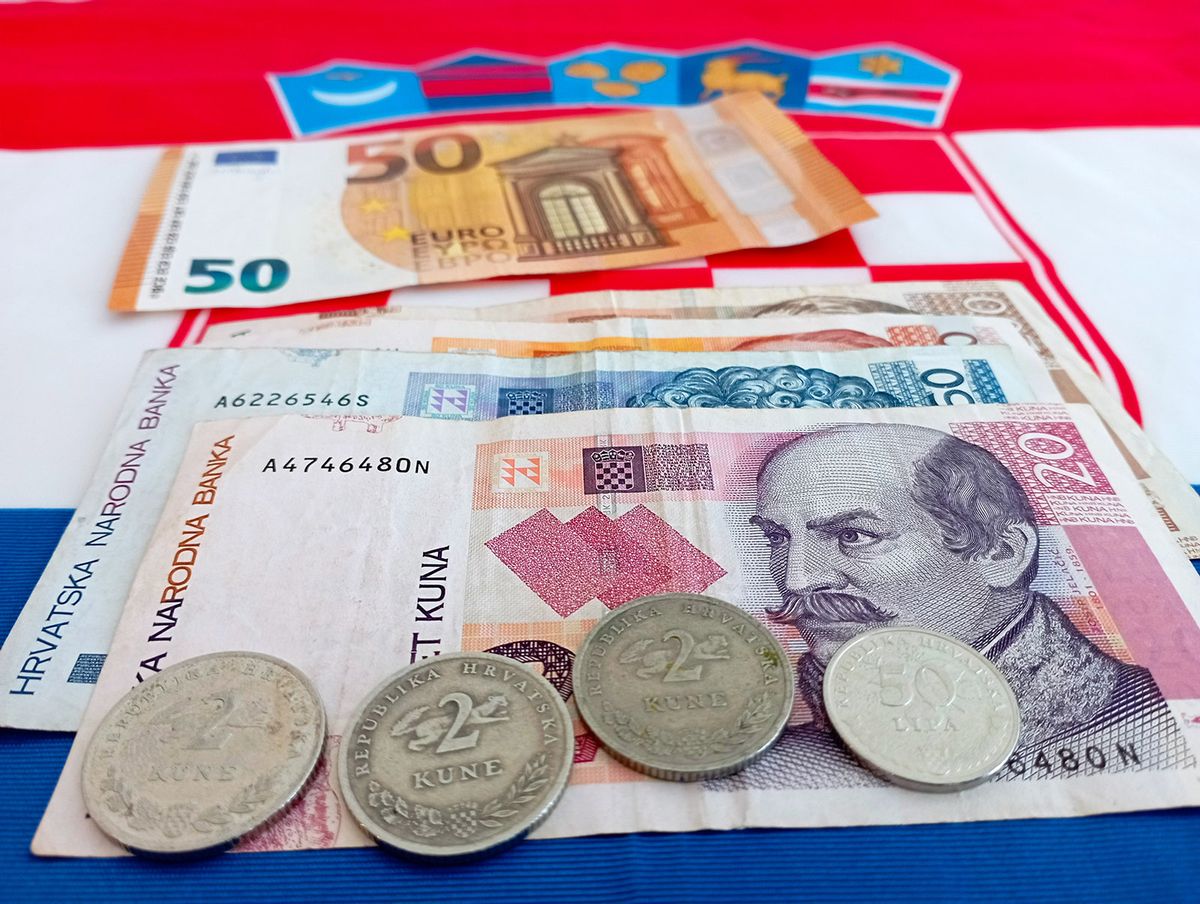 View,Of,Euro,And,Croatia,Bills,With,Croatian,Flag,InView of euro and croatia bills with croatian flag in the background