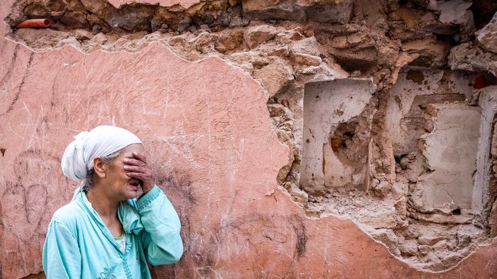 A woman reacts standing infront of her earthquake-damaged house in the old city in Marrakesh on September 9, 2023. A powerful earthquake that shook Morocco late September 8 killed more than 600 people, interior ministry figures showed, sending terrified residents fleeing their homes in the middle of the night. (Photo by FADEL SENNA / AFP)
