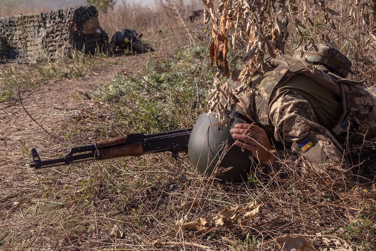 A Ukrainian member of the OPFOR (opposing force) battalion takes cover during a military training in the Donetsk region on September 26, 2023, amid the Russian invasion of Ukraine. (Photo by Roman PILIPEY / AFP)