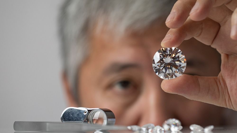 Man,Jeweller,Looking,At,Diamond.,Holding,In,Hand.,Close,Up