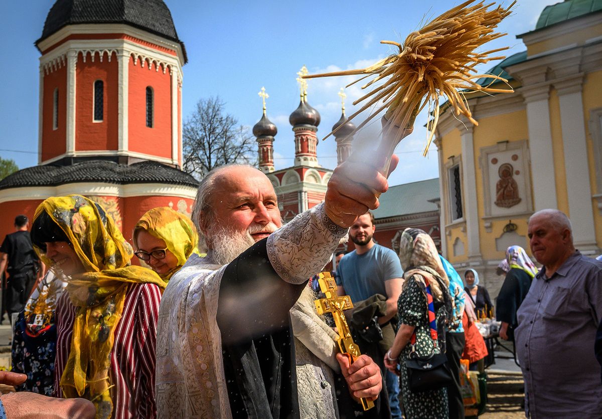 A Russian Orthodox priest blesses Easter eggs and cakes in the yard of an Orthodox monastery in central Moscow on April 27, 2019, on the eve of Orthodox Easter. (Photo by Mladen ANTONOV / AFP)