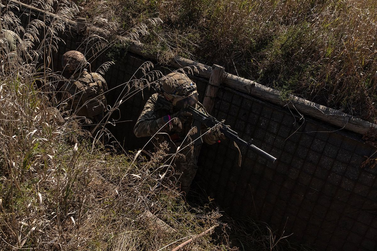 Ukrainian members of the OPFOR (opposing force) battalion move in a trench as they take part in a military training in the Donetsk region on September 26, 2023, amid the Russian invasion of Ukraine. (Photo by Roman PILIPEY / AFP)