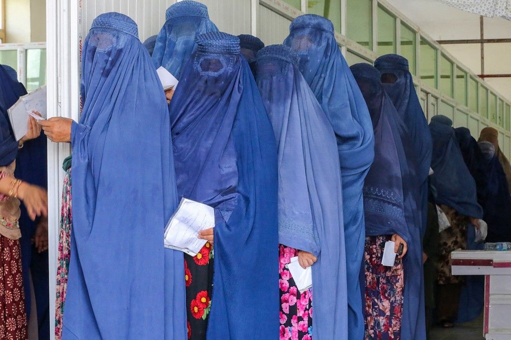 Afghan burqa-clad women wait in a queue to receive money as a humanitarian aid from the International Federation of Red Cross and Red Crescent Societies (IFRC), in Jalalabad on August 6, 2023. (Photo by Shafiullah KAKAR / AFP)