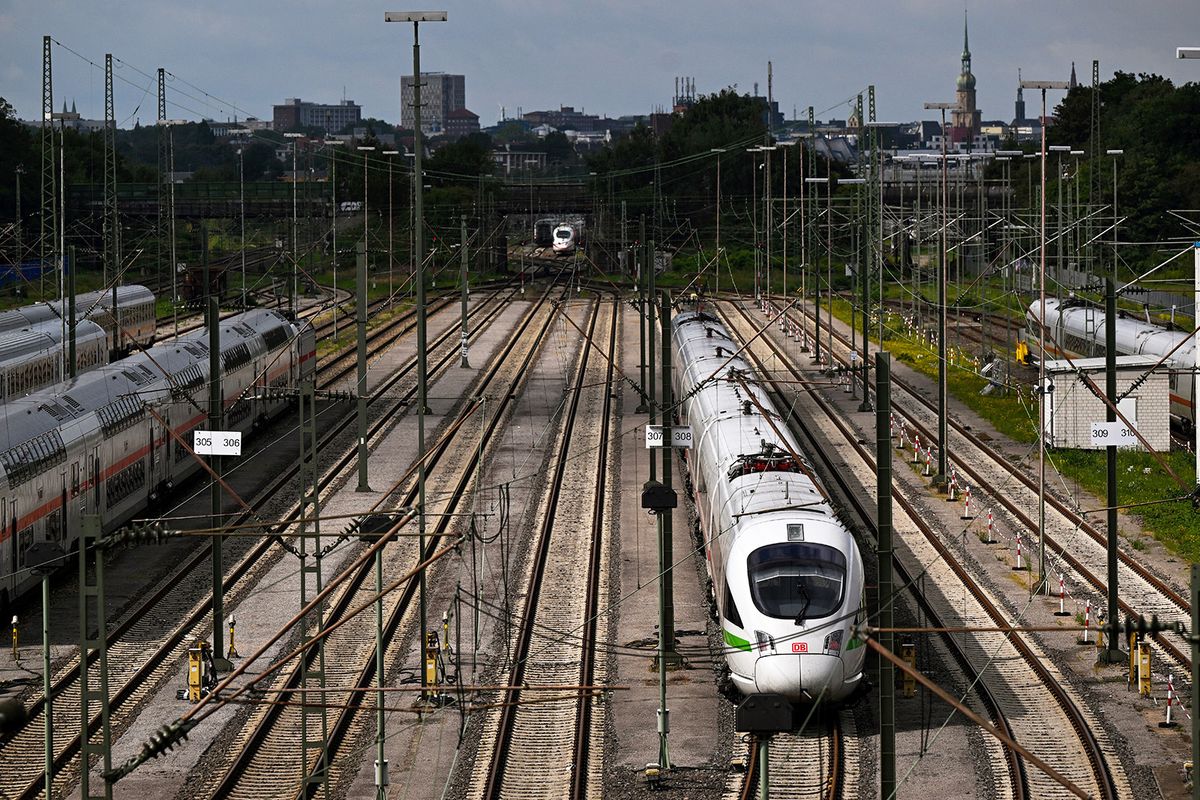 An ICE Inter City Express train (R) of German railway operator Deutsche Bahn (DB) and IC Inter City trains stand on sidings at a depot in Dortmund, western Germany on August 8, 2023. (Photo by Ina FASSBENDER / AFP)
