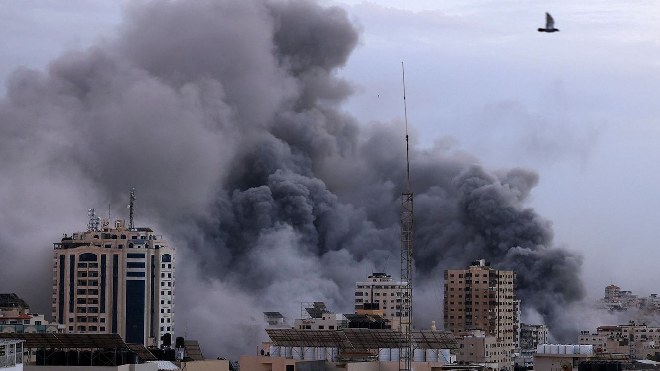 A black plume of smoke billows behind highrise buildings during an Israeli airstrike on Gaza City on October 9, 2023. Israel relentlessly pounded the Gaza Strip overnight and into October 9 as fighting with Hamas continued around the Gaza Strip, as the death toll from the war against the Palestinian militants surged above 1,100. (Photo by MAHMUD HAMS / AFP)