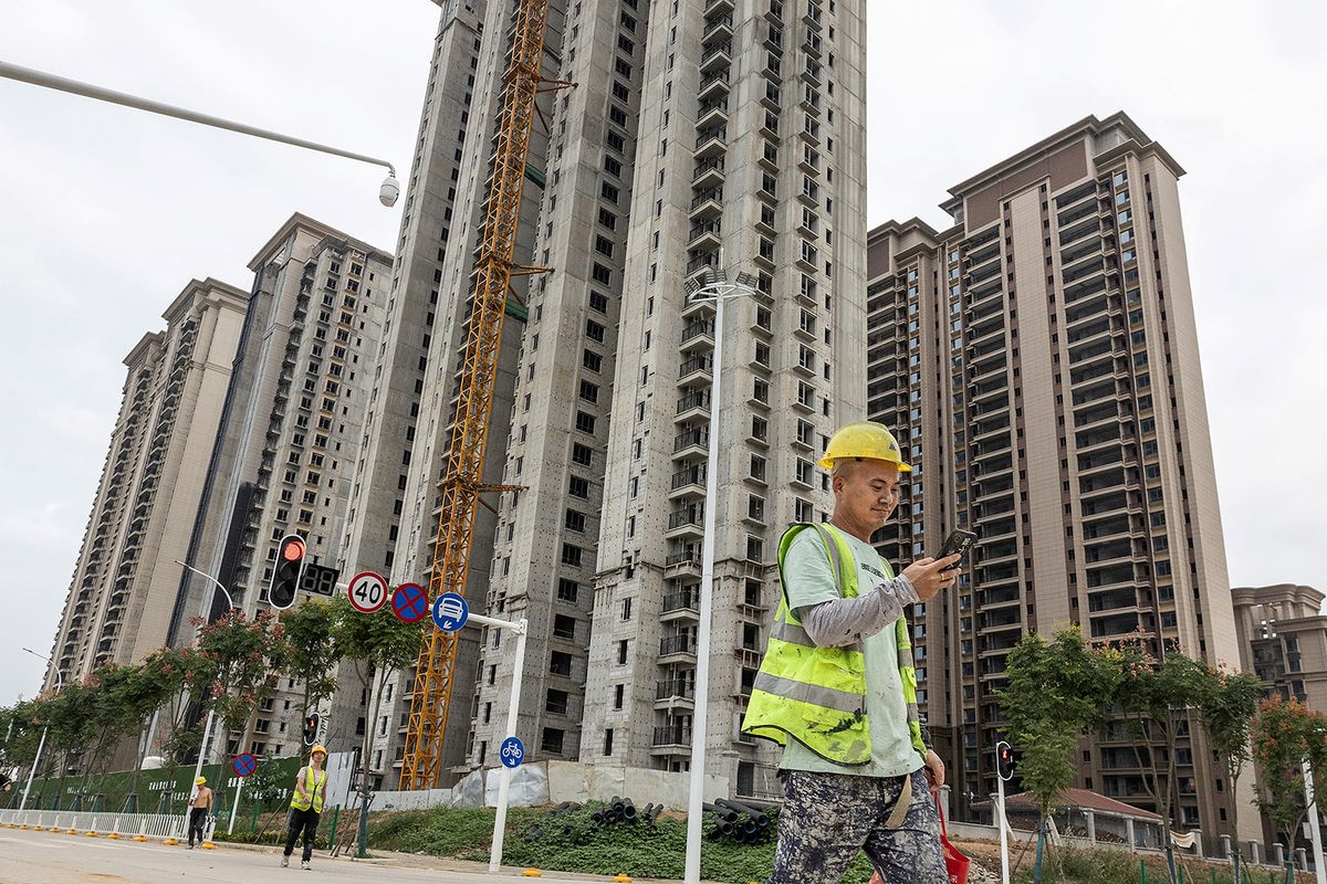 A worker walks past a housing complex under construction by Chinese property developer Evergrande in Wuhan, in China's central Hubei province on September 28, 2023. (Photo by AFP) / China OUT
