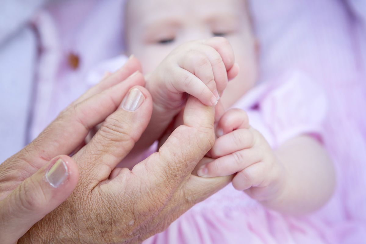 Close,Up,Grandmother,Hands,Holding,Baby,Hands