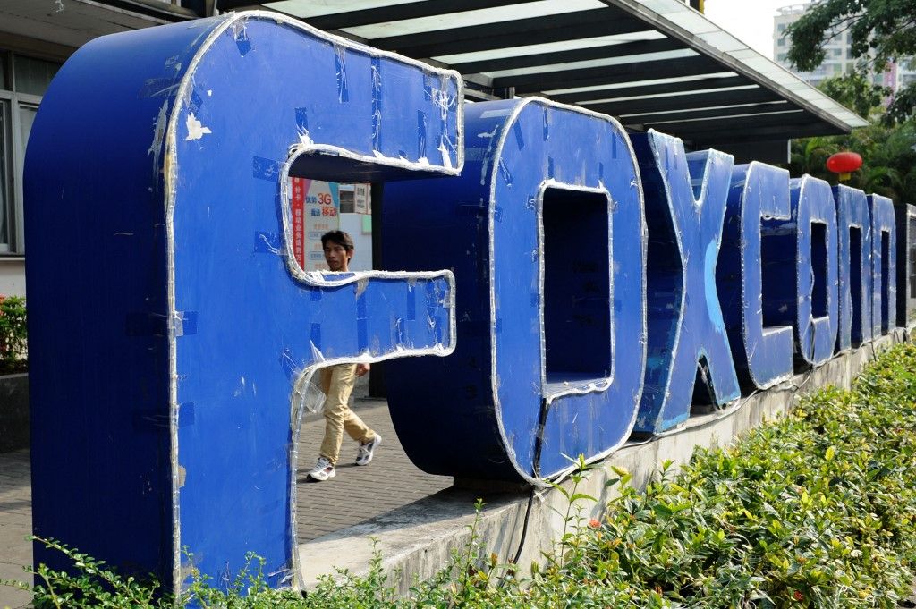 (FILES) This file picture taken on February 22, 2013 shows a person walking past a Foxconn recruitment point in Shenzhen, south China's Guangdong province. Taiwanese tech giant Foxconn is under tax and land use investigations at several of its sites in China, state media reported on October 22, 2023. (Photo by AFP) / China OUT