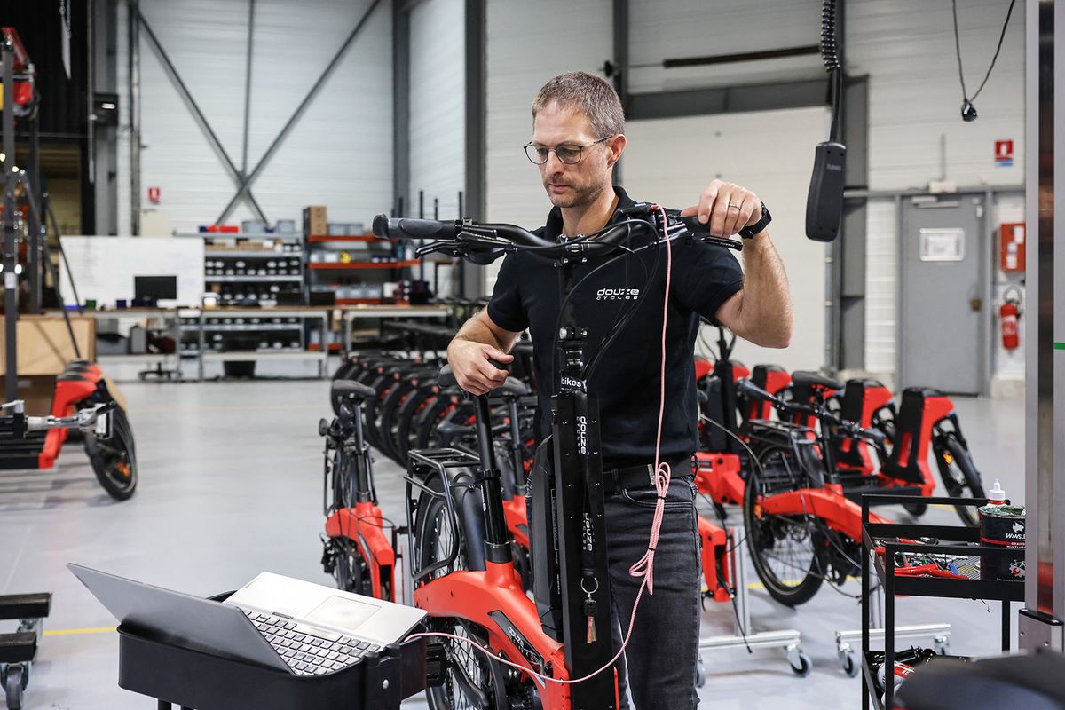 An employee works on a production line for the new bike model developed in partnership with Japanese carmaker Toyota at the Douze Cycles factory in Longvic, eastern France, on September 22, 2023. (Photo by ARNAUD FINISTRE / AFP)