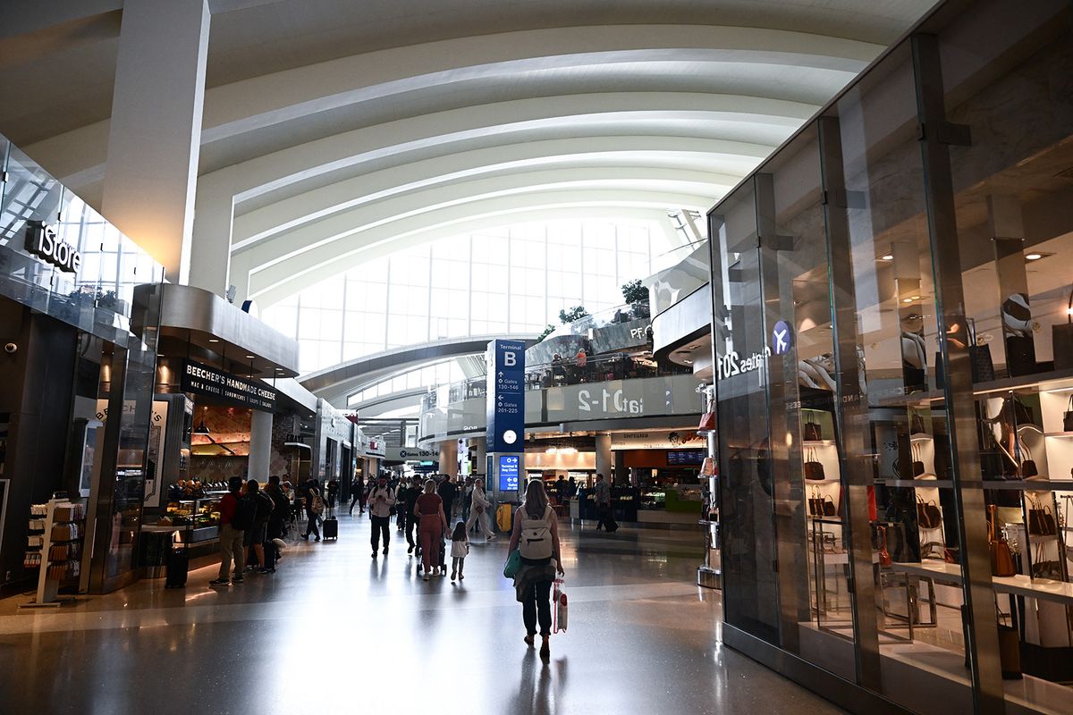 Travelers walk past retail stores and restaurants inside the Tom Bradley International Terminal (TBIT) at Los Angeles International Airport (LAX) in Los Angeles, California on May 17, 2023. (Photo by Patrick T. Fallon / AFP)