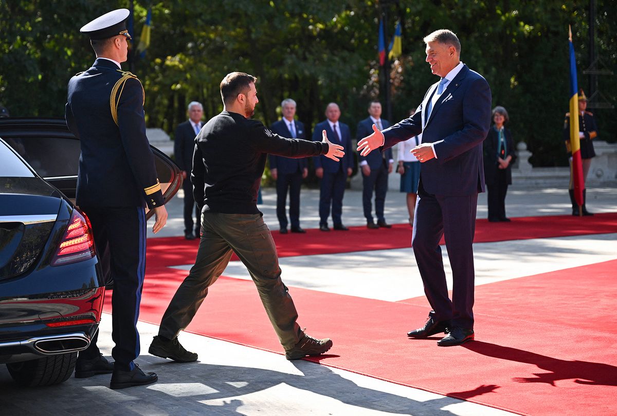 Ukrainian President Volodymyr Zelensky (L) and his Romanian counterpart Klaus Iohannis shake hands as he arrives at the Cotroceni Palace, the Romanian Presidency headquarters in Bucharest on October 10, 2023. (Photo by Daniel MIHAILESCU / AFP)