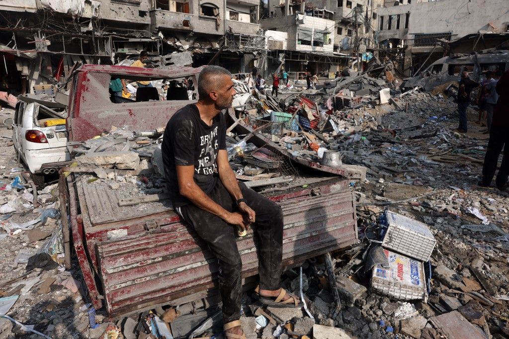 A man sits amid the destruction following Israeli strikes on Al-Shatee camp in Gaza City on October 28, 2023. Israeli air strikes destroyed hundreds of buildings in the Gaza Strip overnight, the civil defence service in the Hamas-controlled Palestinian territory said on October 28. (Photo by MOHAMMED ABED / AFP)