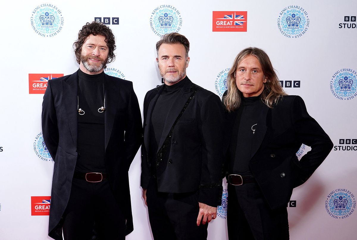 Members of Take That (L-R) Howard Donald, Gary Barlow and Mark Owen pose for a photograph on the red carpet ahead of attending the Coronation Concert inside Windsor Castle grounds in Windsor, west of London on May 7, 2023. For the first time ever, the East Terrace of Windsor Castle will host a spectacular live concert that will also be seen in over 100 countries around the world. The event will be attended by 20,000 members of the public from across the UK. (Photo by Ian West / POOL / AFP)