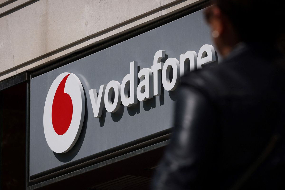 A pedestrian walks past a Vodafone store in central London on May 16, 2023. British mobile giant Vodafone is to axe 11,000 jobs over three years in the latest cull to hit the tech sector, as new boss Margherita Della Valle slammed recent performance. (Photo by Adrian DENNIS / AFP)