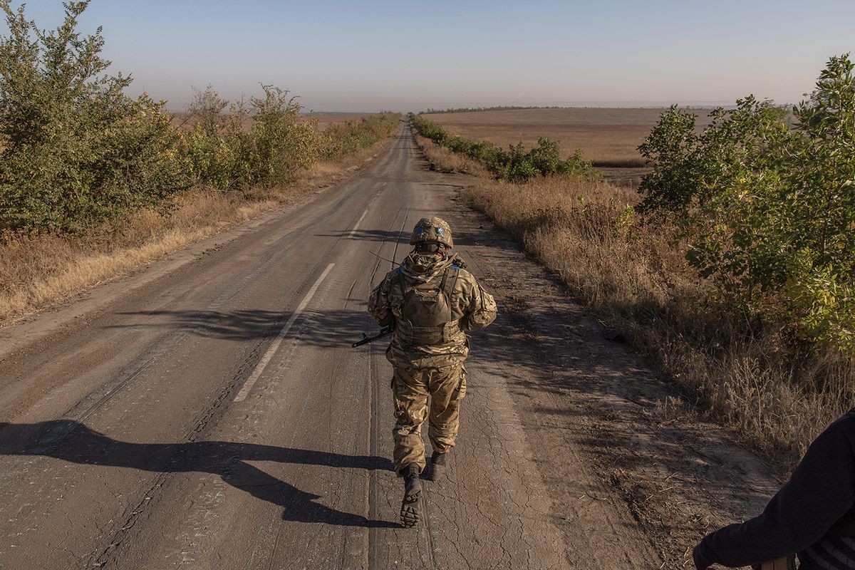A Ukrainian soldier of the 65th Mechanized Brigade walks on a road near the frontline village of Robotyne, in the Zaporizhzhia region, on October 1, 2023, amid the Russian invasion of Ukraine. (Photo by Roman PILIPEY / AFP)