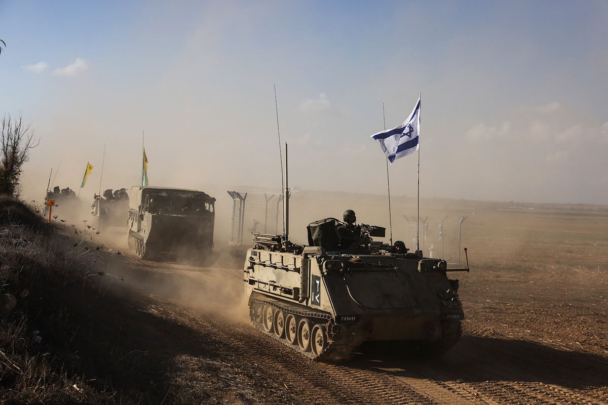 A convoy of Israeli military vehicles drives down a road at an undisclosed location on the border with the Gaza Strip on October 15, 2023. More than one million people have been displaced in the Gaza Strip in the last week, the UN said on October 15, after a week of Israeli bombardment and warnings about a ground attack against Hamas commanders. (Photo by Menahem KAHANA / AFP)