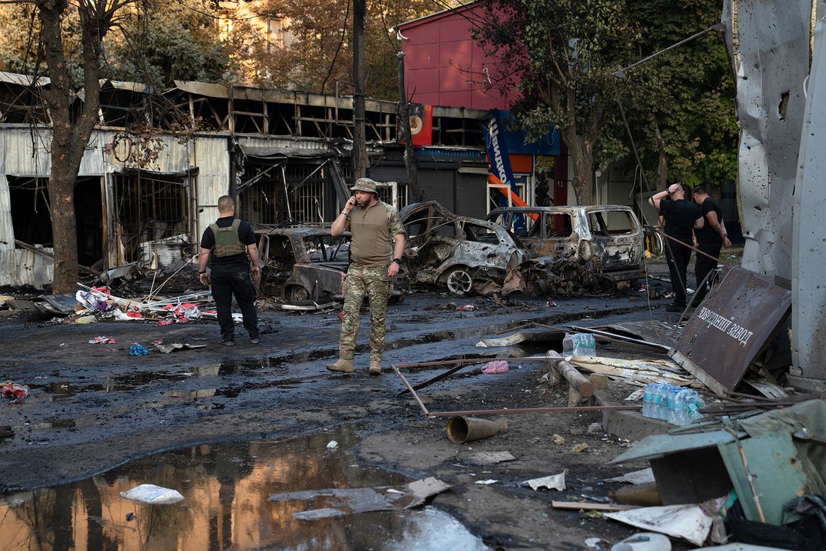 A Ukrainian military member walks past burned cars at a market following a Russian strike in Kostyantynivka, Ukraine's eastern Donetsk region on September 6, 2023, amid the Russian invasion of Ukraine. A Russian strike killed at least 17 people at a market in east Ukraine, officials said, in an attack that President Volodymyr Zelensky described as deliberate and "heinous". (Photo by Polina MELNYK / AFP)