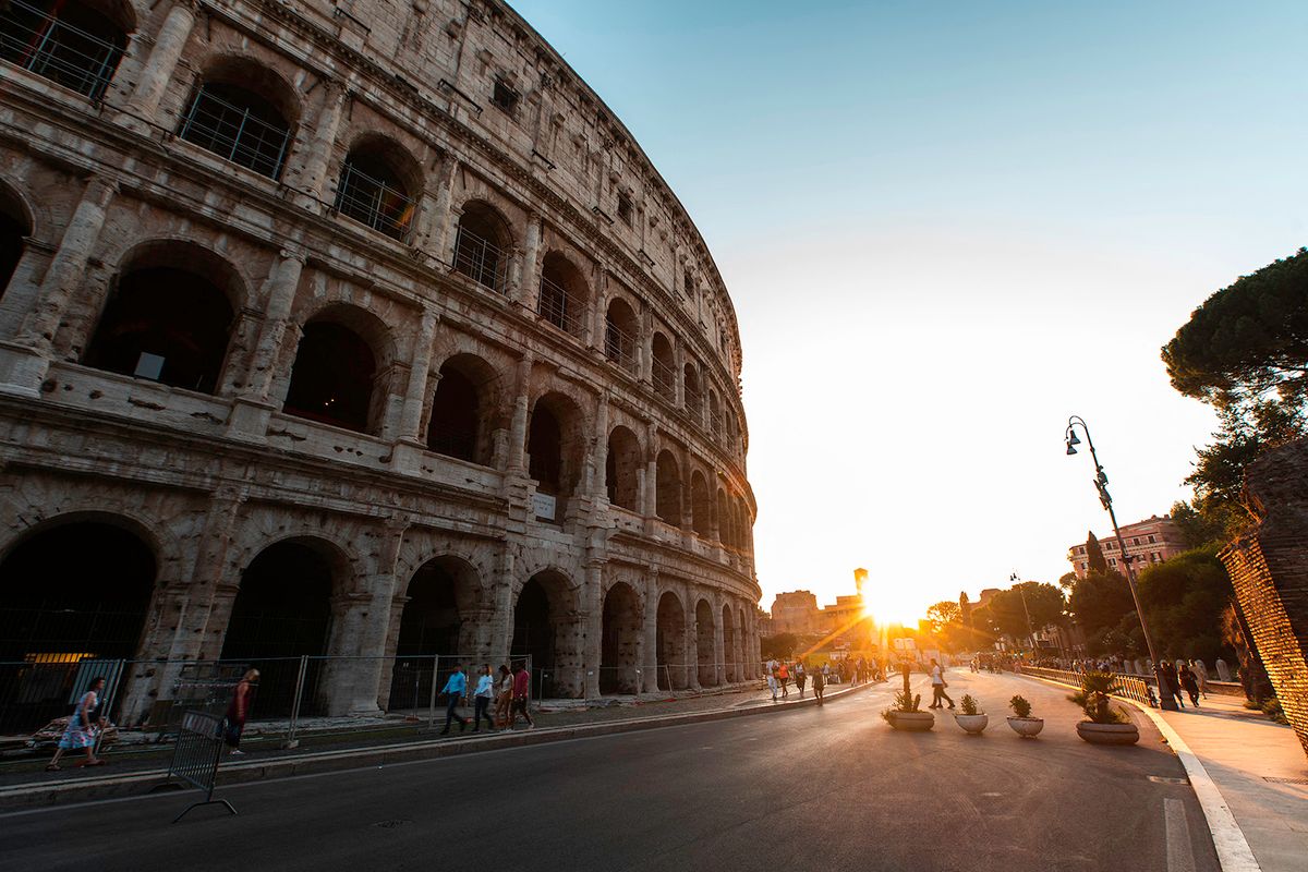 Low angle view of tourists walking on street outside Colosseum, Rome (Photo by Pablo Camacho / AltoPress / PhotoAlto via AFP)