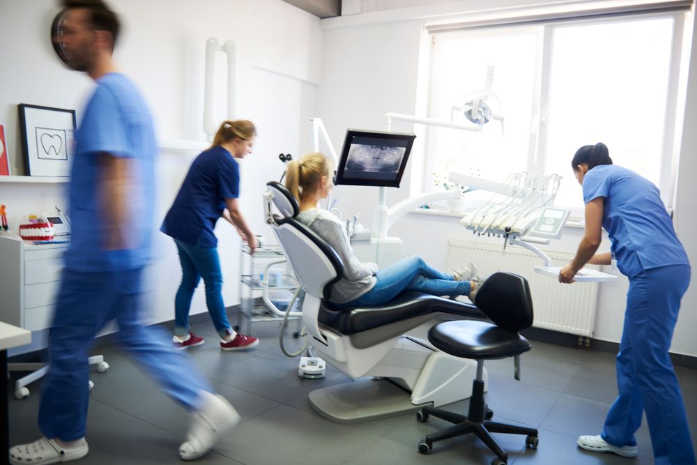 Blurred,View,Of,Dentists,And,Woman,In,Dentist's,Clinic