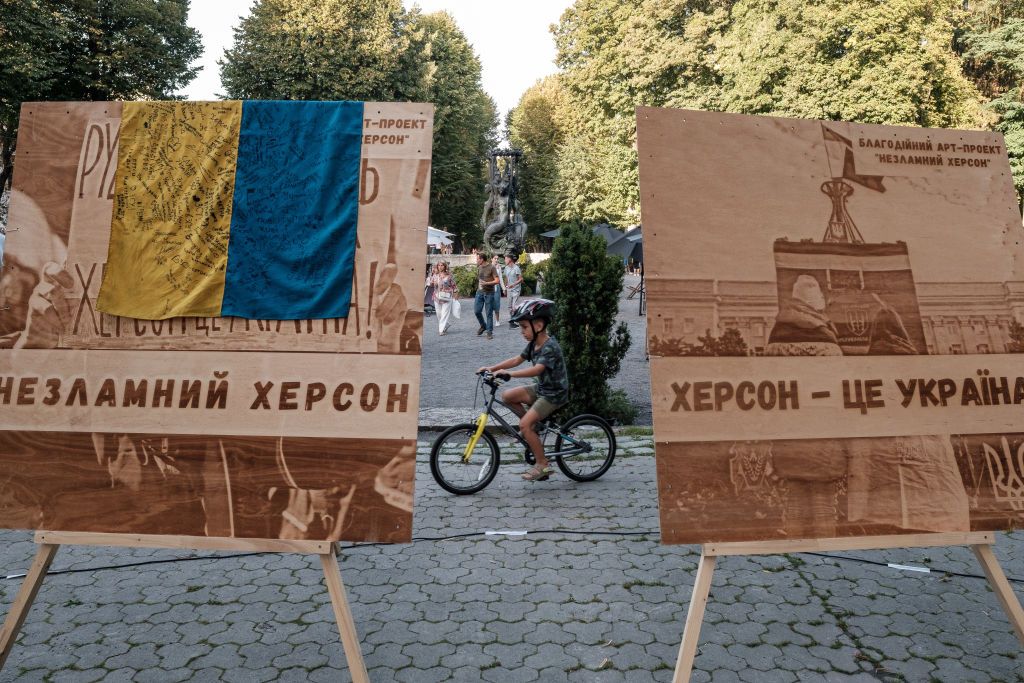 Lviv Hosts The Unbroken Kherson Charity Art ProjectLVIV, UKRAINE - SEPTEMBER 10: A boy on a bicycle passes banners “Unbroken Kherson” and “Kherson is Ukraine” during “Unbroken Kherson” charity action on September 10, 2023 in Lviv, Ukraine. The project is aimed to raise funds for the inhabitants and servicepersons of Kherson. (Photo by Les Kasyanov/Global Images Ukraine via Getty Images)