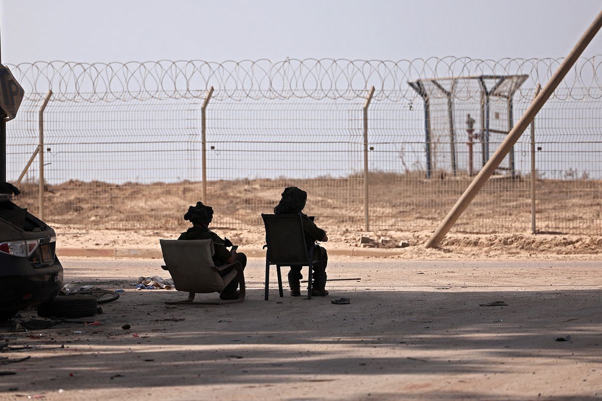 In this picture taken during a media tour organised by the Israeli military on October 22, 2023, Israeli soldiers guard Kibbutz Beeri along the border with the Gaza Strip, in the aftermath of a Palestinian militant attack on October 7. (Photo by Thomas COEX / AFP)