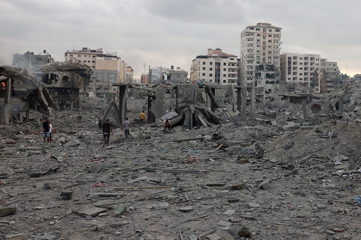 Palestinians inspect the destruction following Israeli airstrikes on Gaza City's al-Rimal district, early on October 10, 2023. Israel kept up its deadly bombardment of Hamas-controlled Gaza on October 10 after the Palestinian militant group threatened to execute some of the around 150 hostages it abducted in a weekend assault if air strikes continue without warning. (Photo by MOHAMMED ABED / AFP)