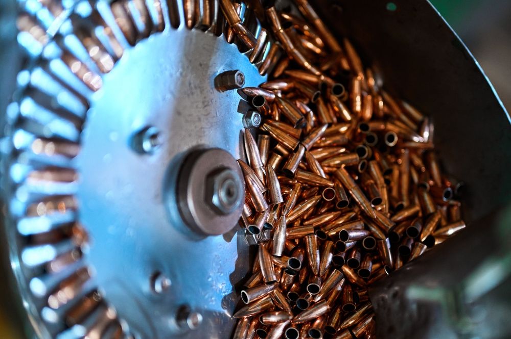 Pile,Of,Copper,Bullet,Shells,And,Turning,Wheel,At,Production