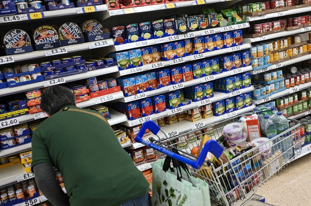 A customer looks at some canned food at the Tesco supermarket, in Aylesbury, England, on August 15, 2023. UK annual inflation stands at 7.9 percent, the highest among G7 nations, while the Bank of England is tasked by the UK government with keeping annual inflation at around two percent. (Photo by JUSTIN TALLIS / AFP)