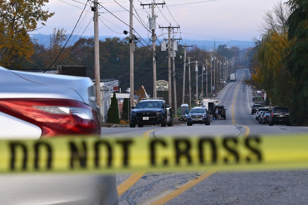 Police tape blocks off the street near Schemengees Bar and Grille in Lewiston, Maine, on October 27, 2023, in the aftermath of a mass shooting. Hundreds of police in the US state of Maine hunted October 26, 2023 for a fugitive gunman who killed 18 people at a bowling alley and a bar, as President Joe Biden mourned "yet another senseless and tragic mass shooting." Police named the suspect as 40-year-old Robert Card -- seen in surveillance footage pointing a semi-automatic rifle as he walked into the Sparetime Recreation bowling alley. (Photo by ANGELA WEISS / AFP)