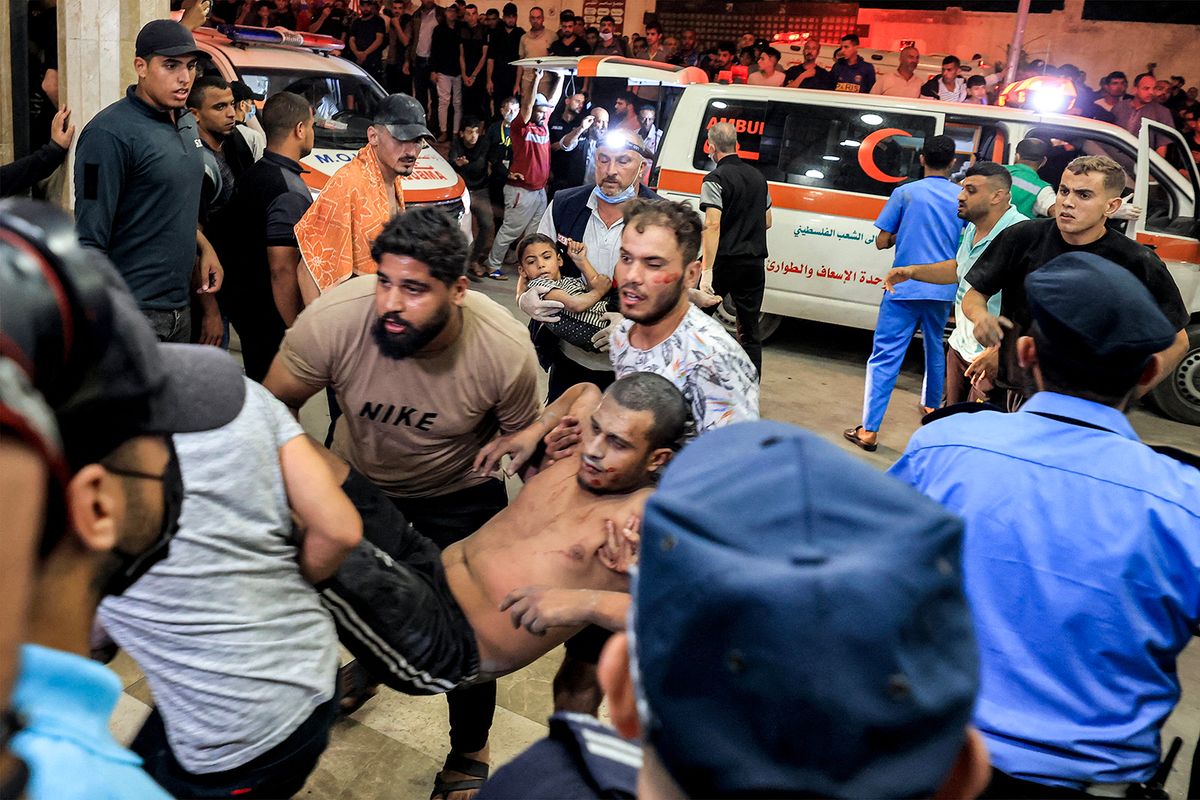 EDITORS NOTE: Graphic content / A man who was injured in Israeli bombardment is carried to the entrance for emergency treatment at Nasser hospital in Khan Yunis in the southern Gaza Strip on October 24, 2023 amid the ongoing battles between Israel and the Palestinian group Hamas. Thousands of civilians, both Palestinians and Israelis, have died since October 7, 2023, after Palestinian Hamas militants based in the Gaza Strip entered southern Israel in an unprecedented attack triggering a war declared by Israel on Hamas with retaliatory bombings on Gaza. (Photo by MAHMUD HAMS / AFP)